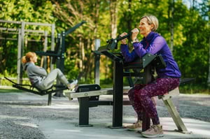 People working out at an outdoor gym in the woods