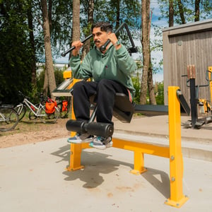 A person working out abs at an outdoor gym