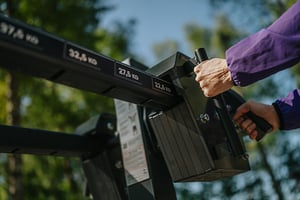 Woman adjusting weight on outdoor gym equipment